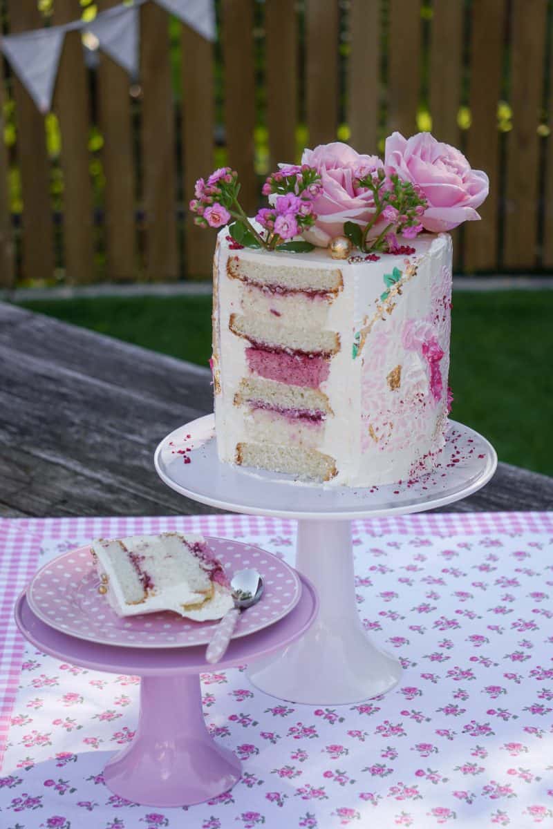 Розово-бяла торта върху розова покривка.