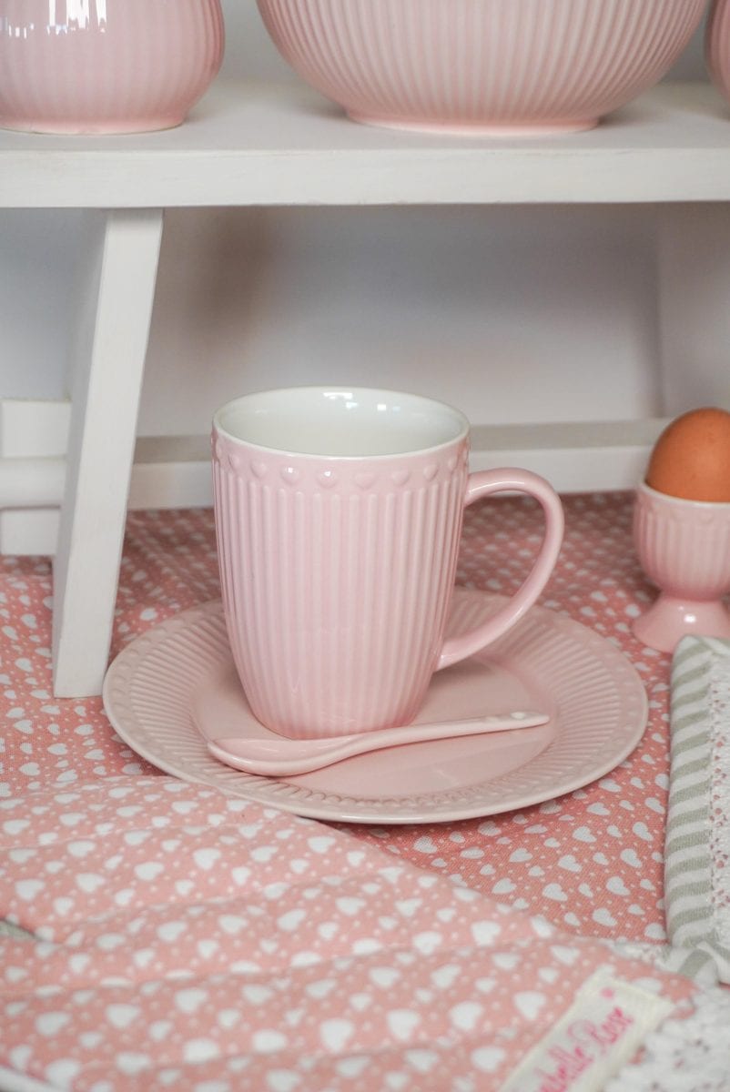 Розова чаша и чинийка стоят на рафт.